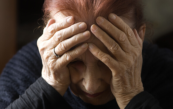 Gewalt gegen Senioren, alte Dame hält sich Hände vors Gesicht