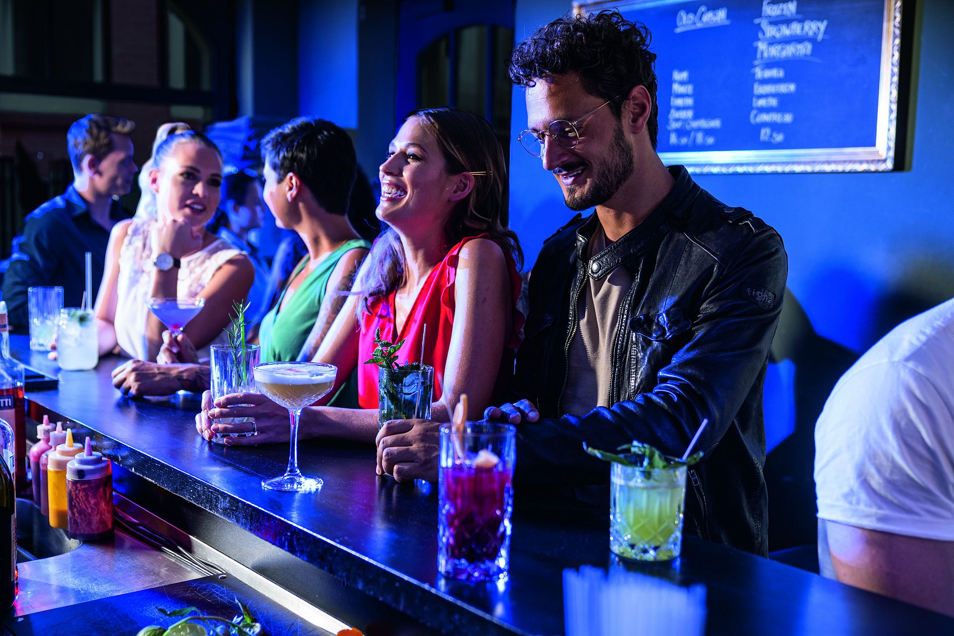 Junge Leute feiern bei ein paar Drinks in einer Bar.