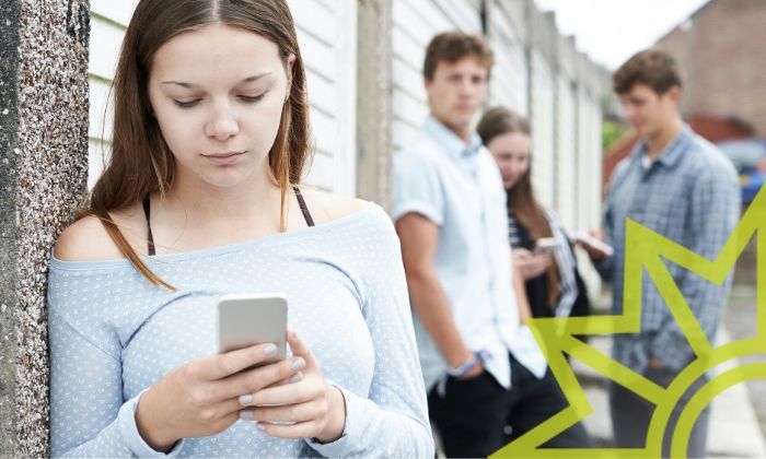 Mädchen mit Smartphone und Teenager im Hintergrund