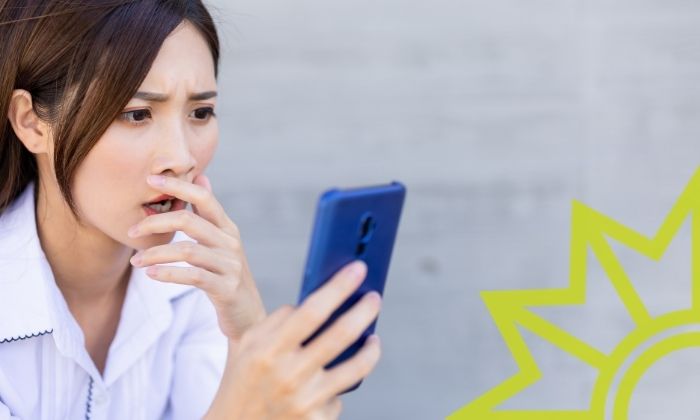 Junge Frau sieht Falschmeldungen auf ihrem Smartphone