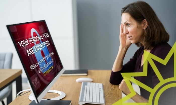 Frau sitzt vor einem mit Ransomware infizierten Computer