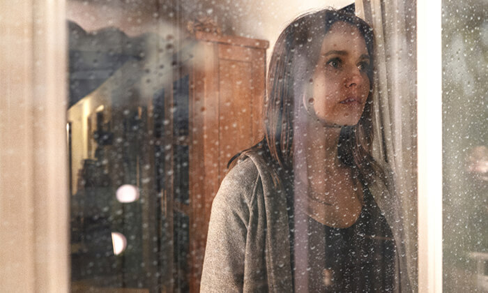 Frau schaut traurig aus dem Fenster - Sat1 Themenfilm über Stalking
