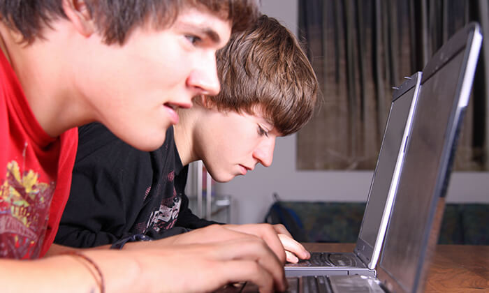 Cybermobbing: Zwei Jungs vor Laptops.