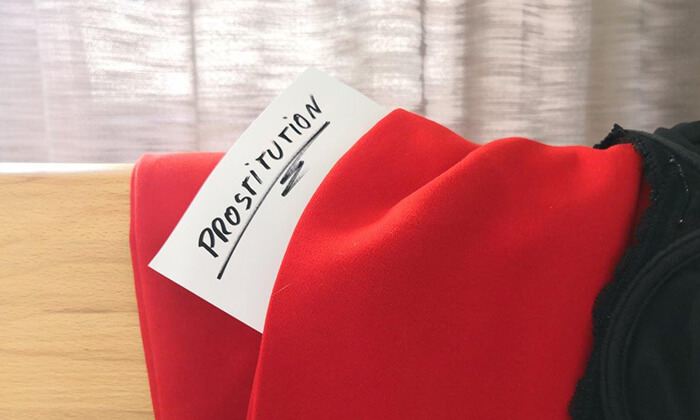 In einer roten Hose steckt ein handgeschrieber Zettel mit der Aufschrift "Prostitution"
