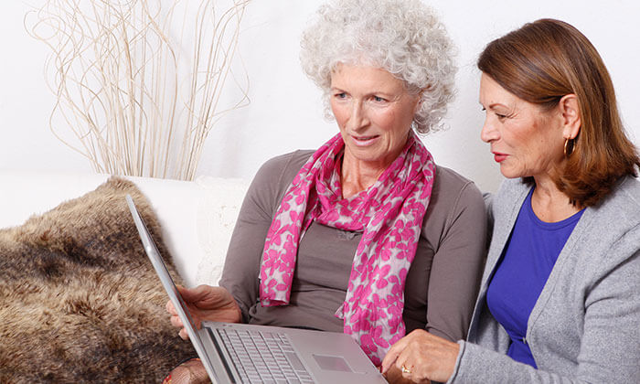 zwei ältere Frauen sitzen vor dem Laptop
