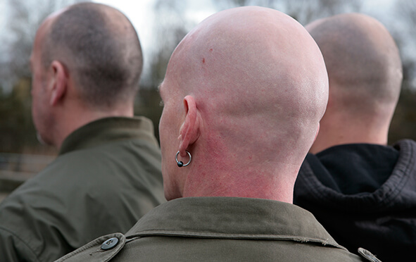 Rechtsextremismus - Männer von hinten mit rasiertem Kopf 