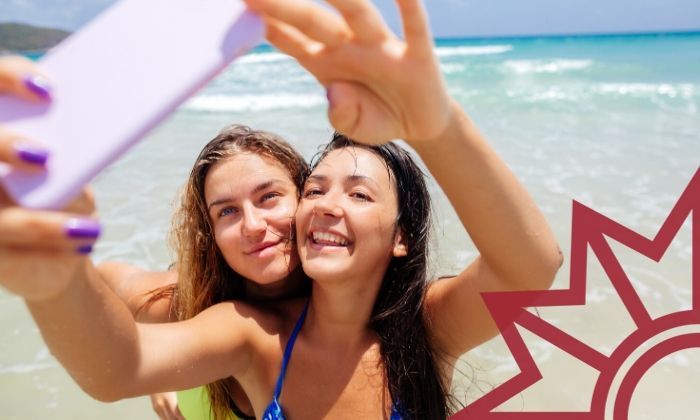 Zwei Mädchen am Strand machen ein Selfie mit dem Smartphone