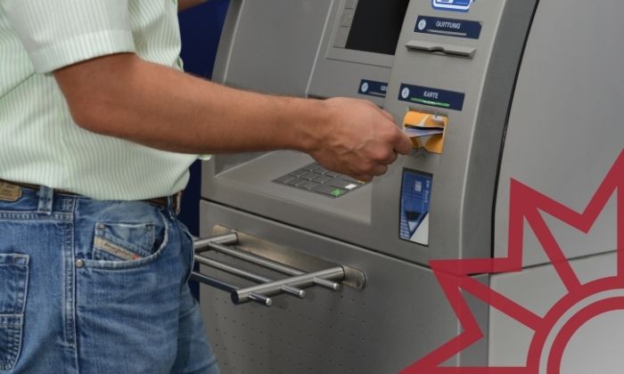 Mann hebt Geld am Geldautomaten ab.