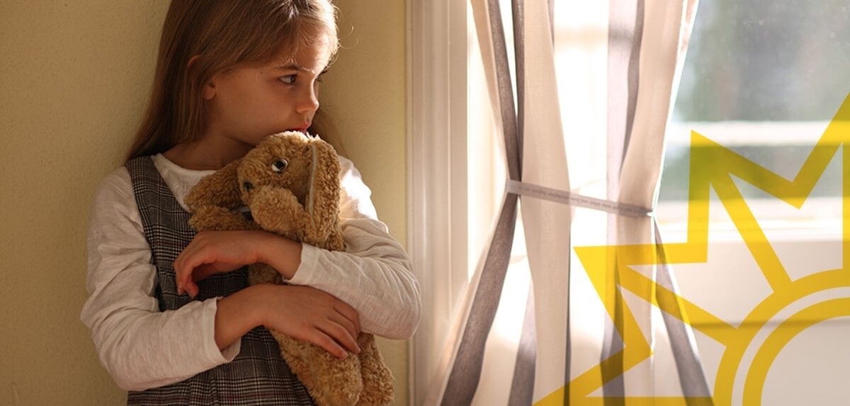 Trauriges Mädchen hält Teddy-Bär im Arm.