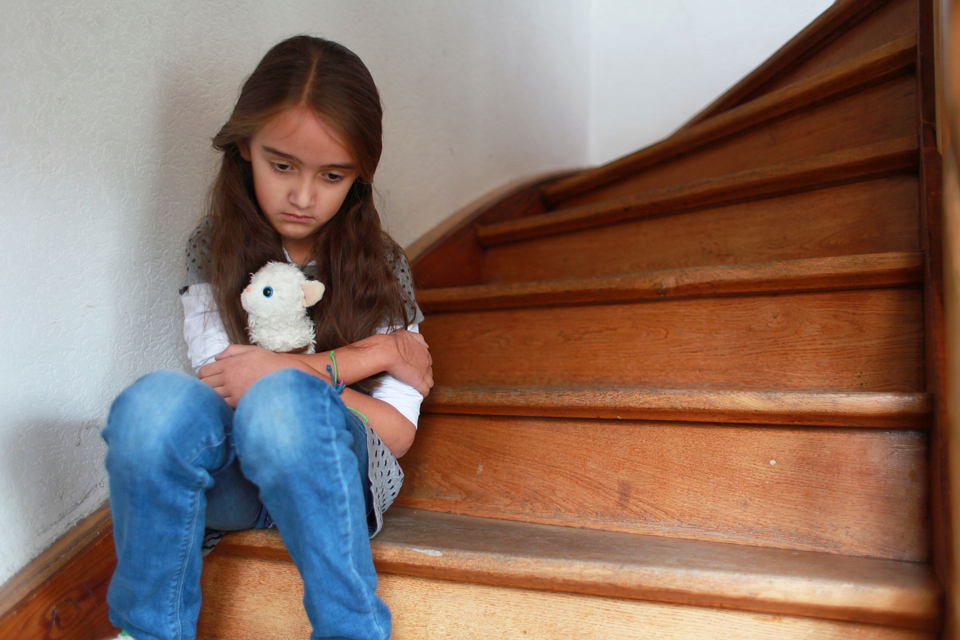 Traumatisiertes Mädchen sitzt auf der Treppe.