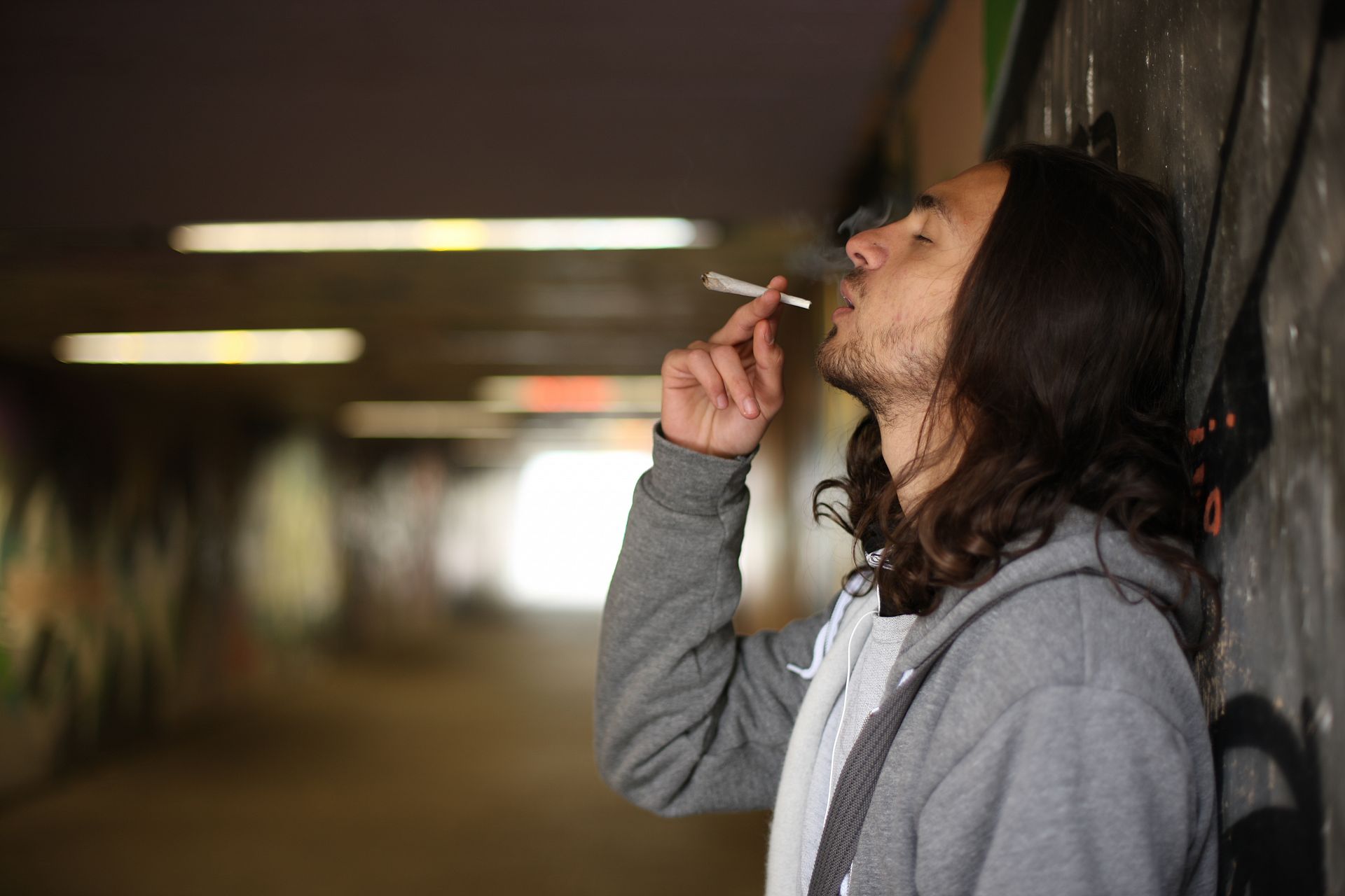 Jugendlicher raucht einen Joint in einer Unterführung.