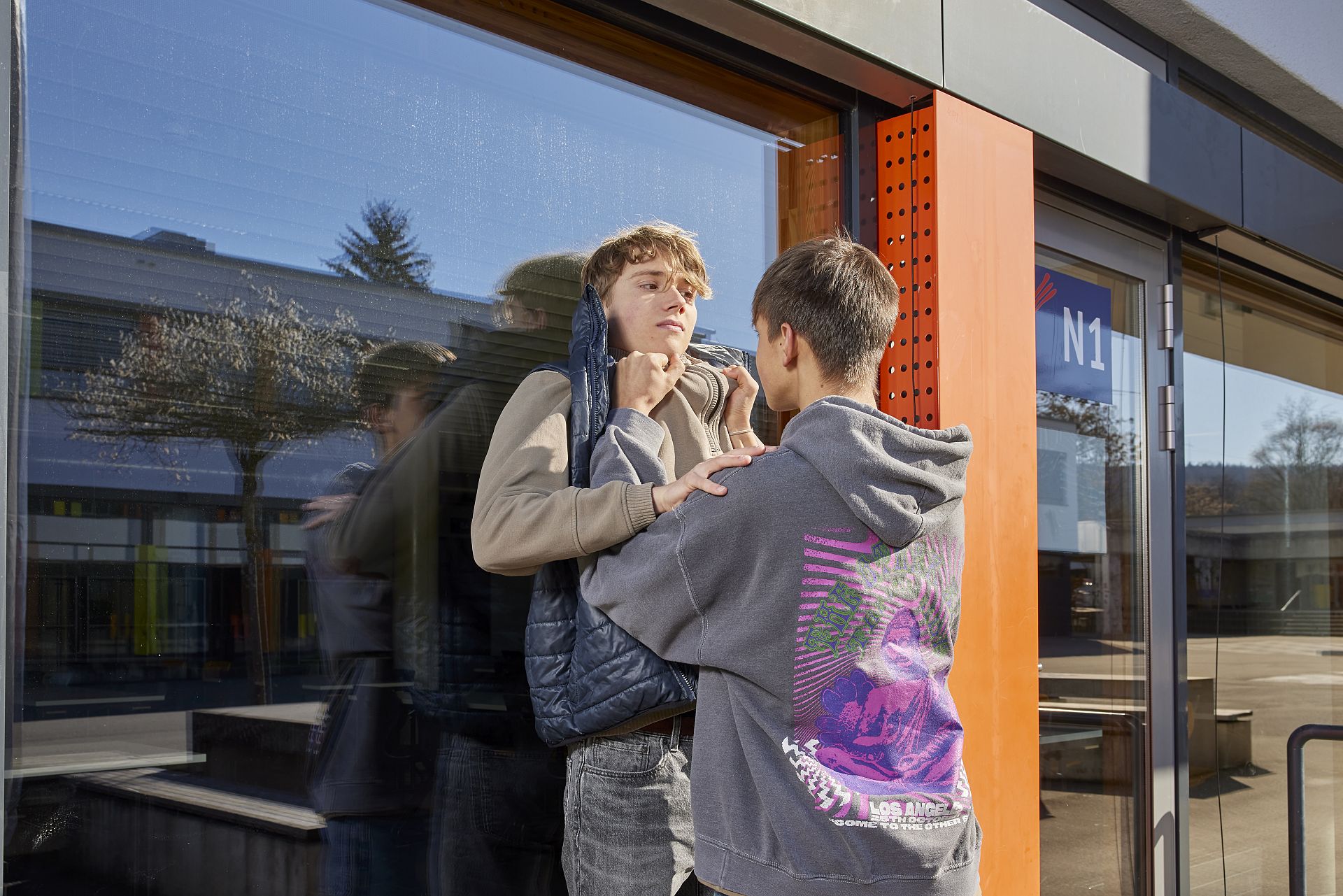 Zwei Teenager raufen auf dem Schulhof.