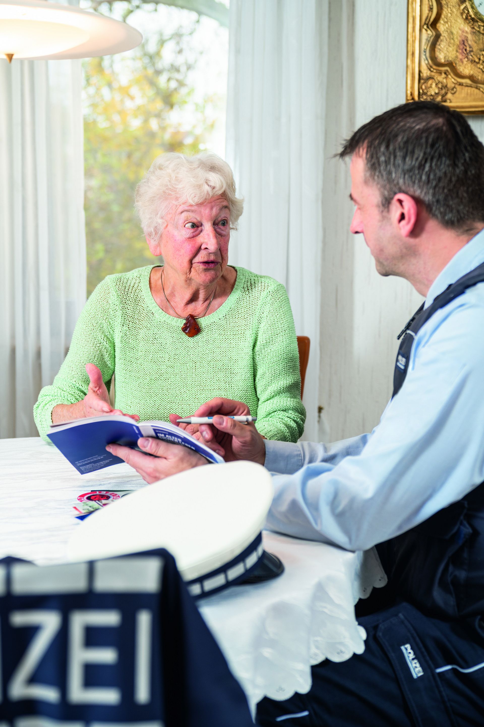 Seniorin im Beratungsgespräch mit einem Polizisten.