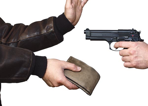 Symbolisch dargstellter Raub einer Geldbörse: Hand mit Pistole und Hände eines Ausgeraubten.