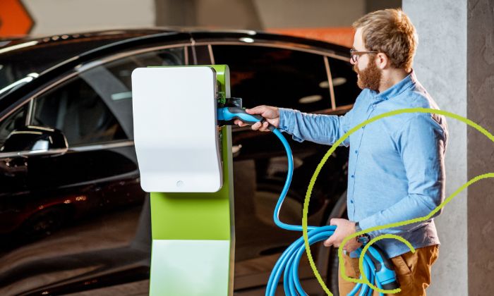 Mann prüft Batterie eines E-Autos vor dem Gebrauchtkauf.