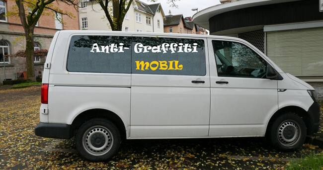 Ein weißer Kleintransporter mit der Aufschrift „Anti-Graffiti Mobil“ steht an einer Straße. Das Fahrzeug gehört zu einem kommunalen Projekt zur Entfernung von illegalen Graffiti.
