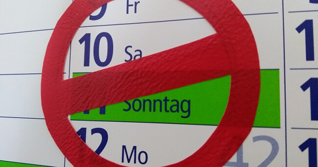 Ein Kalenderblatt mit dem hervorgehobenen Sonntag, der durch ein großes rotes Verbotsschild durchgestrichen ist - symbolisch für einen autofreien Tag in der Innenstadt.