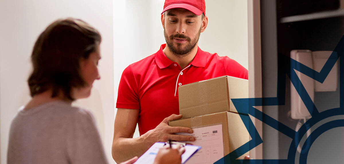 Lieferant gibt einer Frau Pakete an der Wohnungstür ab