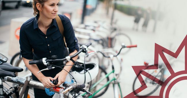 Frau schließt ihr Fahrrad ab.